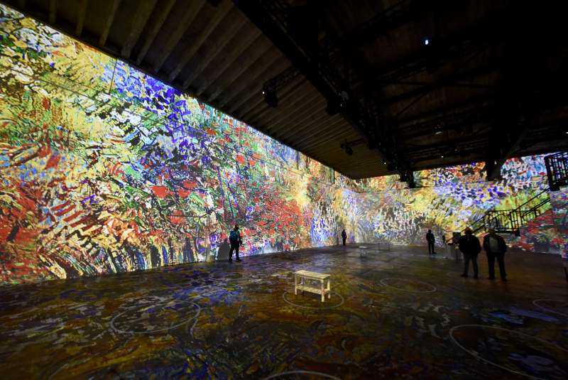 A large room with a wall of flowers projected on it.