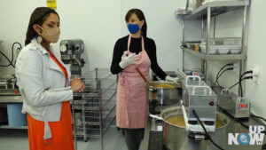 Two women in a kitchen preparing food.